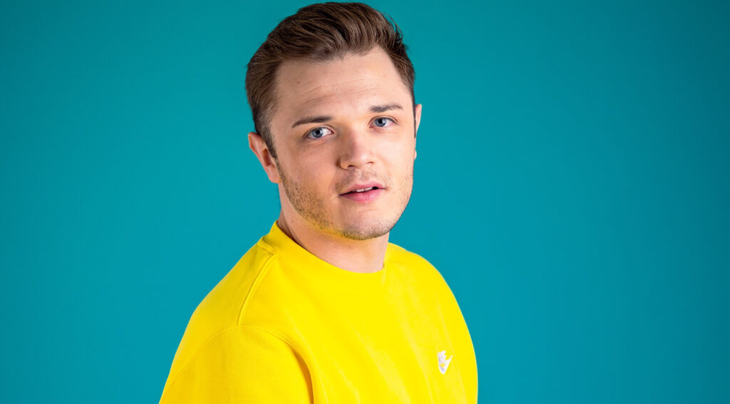 Foto von Kevin Neon im gelben Pullover auf türkisfarbenem Hintergrund